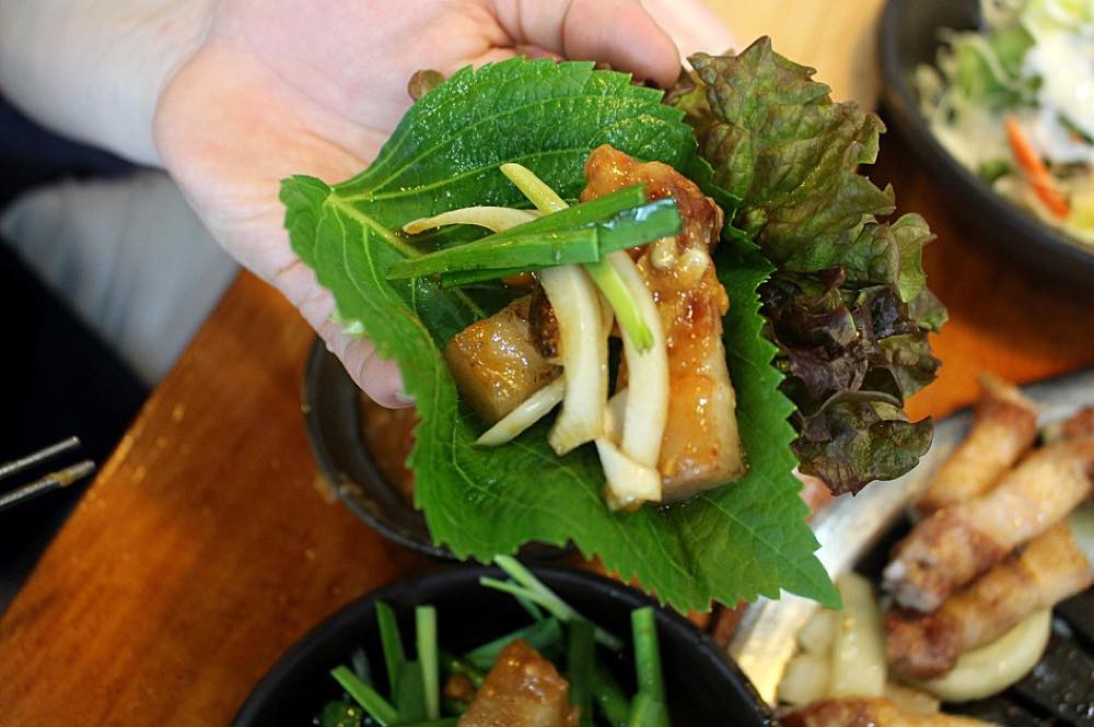 Grilled pork wrapped in lettuce ssam with ssamjang at a Korean BBQ restaurant